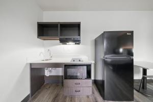a kitchen with a sink and a refrigerator at Southern Suites Columbus in Columbus