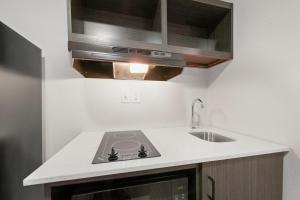 a kitchen with a stove and a sink at Southern Suites Columbus in Columbus