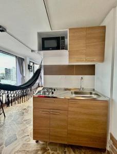 a small kitchen with a sink and a microwave at Open Sky in Manizales