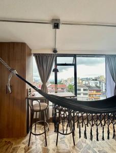 a hammock in a room with a large window at Open Sky in Manizales +12 photos