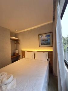 une chambre avec un lit avec des draps blancs et une fenêtre dans l'établissement Casa com piscina - Milagres - Praia e Capela, à São Miguel dos Milagres