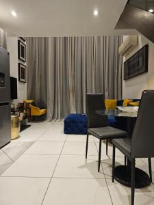 a living room with a table and chairs and a couch at Embassy Garden Luxury in Accra