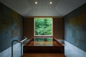 a bathroom with a window and a bath tub at Koorogirou in Kaga