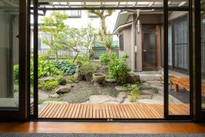 an open door to a garden outside a house at Vacation Home 和BISABI in Matsumoto