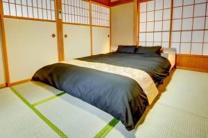a bedroom with a large bed in a room at Vacation Home 和BISABI in Matsumoto