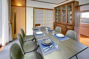 a dining room with a long table and chairs at Vacation Home 和BISABI in Matsumoto
