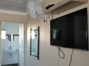 a flat screen tv hanging on a wall in a bathroom at RonVu @ Bertram in East London