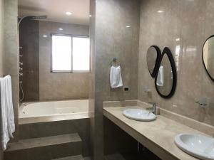 a bathroom with two sinks and a tub and a mirror at Casa Vacacional Jpol in Cali +13 photos