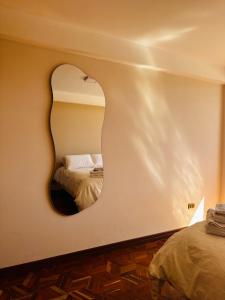 a bedroom with a circular mirror on the wall at NJ Apartment in Uyuni
