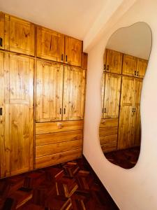 a room with wooden cabinets and a round mirror at NJ Apartment in Uyuni +5 photos