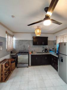 a kitchen with black cabinets and a white refrigerator at Casa Alux Azul in Valladolid