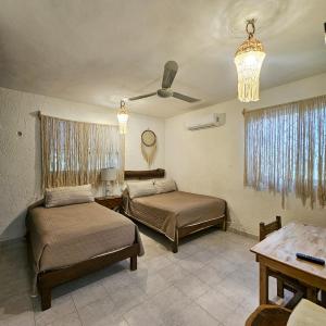 a bedroom with two beds and a ceiling fan at Casa Alux Azul in Valladolid +21 photos