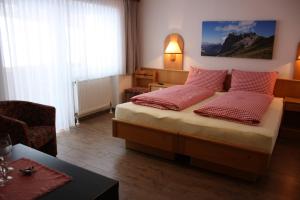 sypialnia z łóżkiem z czerwonymi poduszkami w obiekcie Landhotel Wolf w mieście Leutasch