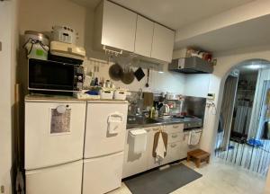 una cucina con elettrodomestici bianchi e frigorifero bianco di Azabujuban Properties 401 - the sanctuary a Tokyo