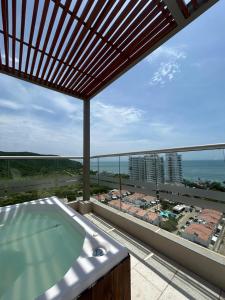a hot tub on a balcony with a view of the ocean at Tu descanso ideal en santa Marta in Gaira