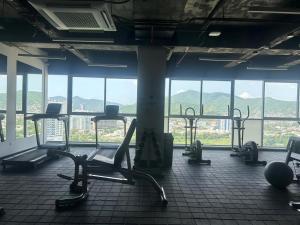 a gym with cardio equipment in a large room with windows at Tu descanso ideal en santa Marta in Gaira