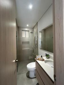 a bathroom with a toilet and a sink and a mirror at Tu descanso ideal en santa Marta in Gaira