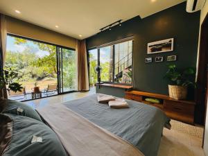 a bedroom with a large bed and a large window at Comfy Riverside Mekong homestay Ben Tre in Ấp Phú Hòa (3)