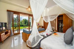 una camera da letto con un letto con tende bianche di Jatining Ubud Villa & Spa ad Ubud Altre 26 foto
