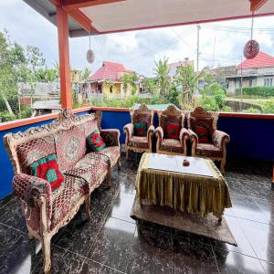 a porch with couches and a table on a house at Anaqi Homestay Mitra RedDoorz in Lahat