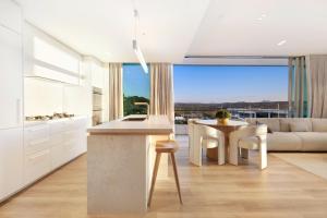 ゴールドコーストにあるMiles at Kirra Point 1406の白いキッチン(テーブル、ソファ付)