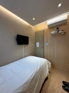 a bedroom with a bed and a flat screen tv at Well Plus Guest House in Seoul