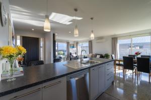 a kitchen with a counter and a dining room at Cozy Haven - Te Anau Holiday Home in Te Anau
