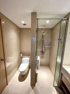 a bathroom with a toilet and a shower at Seaside Skyway apartment Cam Ranh Nha Trang in Cam Lâm