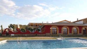 a large swimming pool in front of a house at Hotel Rural Romero Torres in Fuente Obejuna