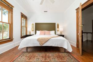 a bedroom with a large bed with white sheets and pink pillows at Be A Nomad - Combined Pool Home 1 blck to Beach in Jacksonville Beach