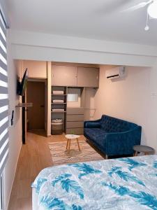 un salon avec un canapé bleu et une table dans l'établissement El Almendrito, à La Sabana