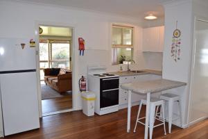 a kitchen with a sink and a stove top oven at Sea Salt Cottage - Bring your own linen. in South West Rocks +6 photos