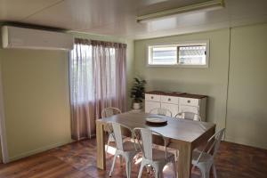 a dining room with a table and chairs and a window at Sea Salt Cottage - Bring your own linen. in South West Rocks