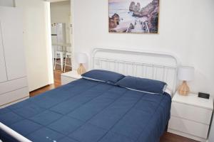 a bedroom with a blue bed and a painting on the wall at Sea Salt Cottage - Bring your own linen. in South West Rocks