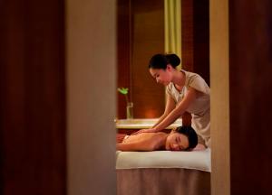 a woman is giving a woman a massage at The Ritz-Carlton, Chengdu in Chengdu