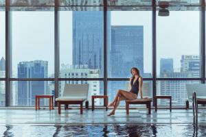 a woman sitting on a chair in a building at The Ritz-Carlton, Chengdu in Chengdu