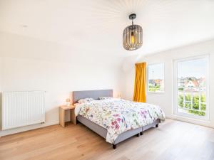 ein weißes Schlafzimmer mit einem Bett und einem Fenster in der Unterkunft Villa in Koksijde near the Sea in Koksijde