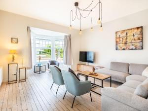 ein Wohnzimmer mit Couch und Stühlen in der Unterkunft Villa in Koksijde near the Sea in Koksijde