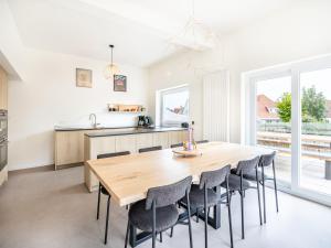 eine Küche und ein Esszimmer mit einem Holztisch und Stühlen in der Unterkunft Villa in Koksijde near the Sea in Koksijde