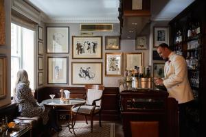 a man standing in a bar talking to a woman at Egerton House in London