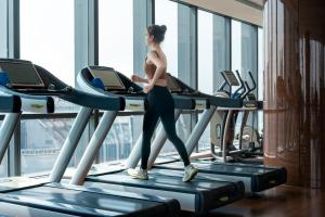 a woman walking on a treadmill in a gym at The Ritz-Carlton, Chengdu in Chengdu