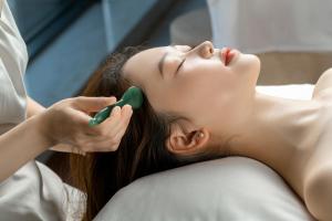 a woman laying on a bed brushing her teeth at The Ritz-Carlton, Chengdu in Chengdu