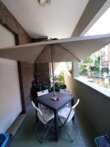 un tavolo e delle sedie sotto un ombrellone in un patio di Arcobaleno a Ferrara