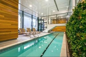 a swimming pool with chairs and a building at 2-Bs Suite Adjacent to Sky Tower in Auckland