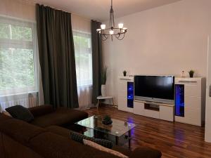 un salon avec un canapé et une télévision à écran plat dans l'établissement KOBLENZ O&O Apartment, à Coblence
