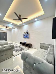 a living room with two couches and a ceiling fan at SFS Family Homestay Kulim in Kulim