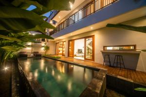 una piscina coperta con un bar in una casa di Alvana Villa Canggu a Canggu