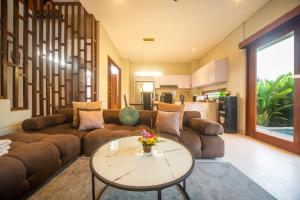 un soggiorno con un divano e un tavolo di Alvana Villa Canggu a Canggu