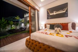 una camera da letto con un letto con un animale di peluche sopra di Alvana Villa Canggu a Canggu Altre 65 foto