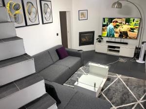 a living room with a couch and a tv at Quiet home in Denderleeuw